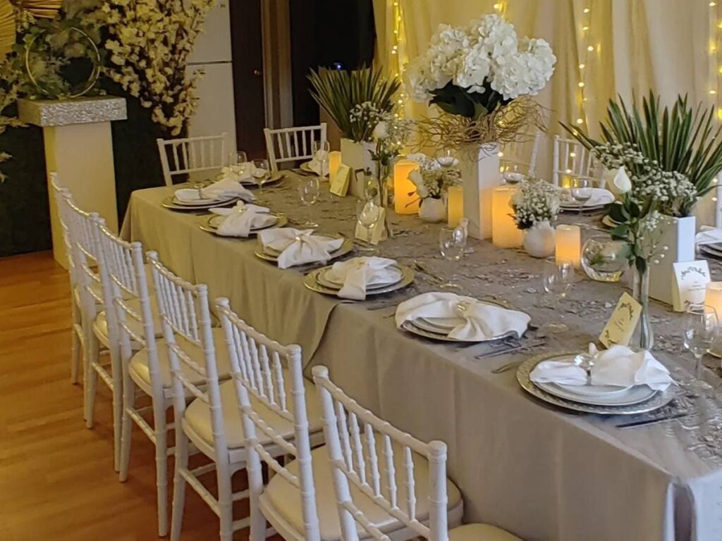 Steel Chiavari Chairs in a wedding table with a floral centerpiece, with background lights